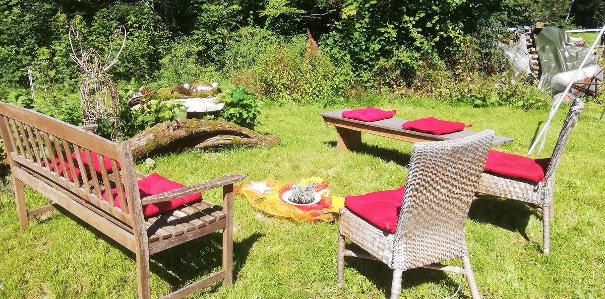 Bank und Stühle im sonnigen Garten