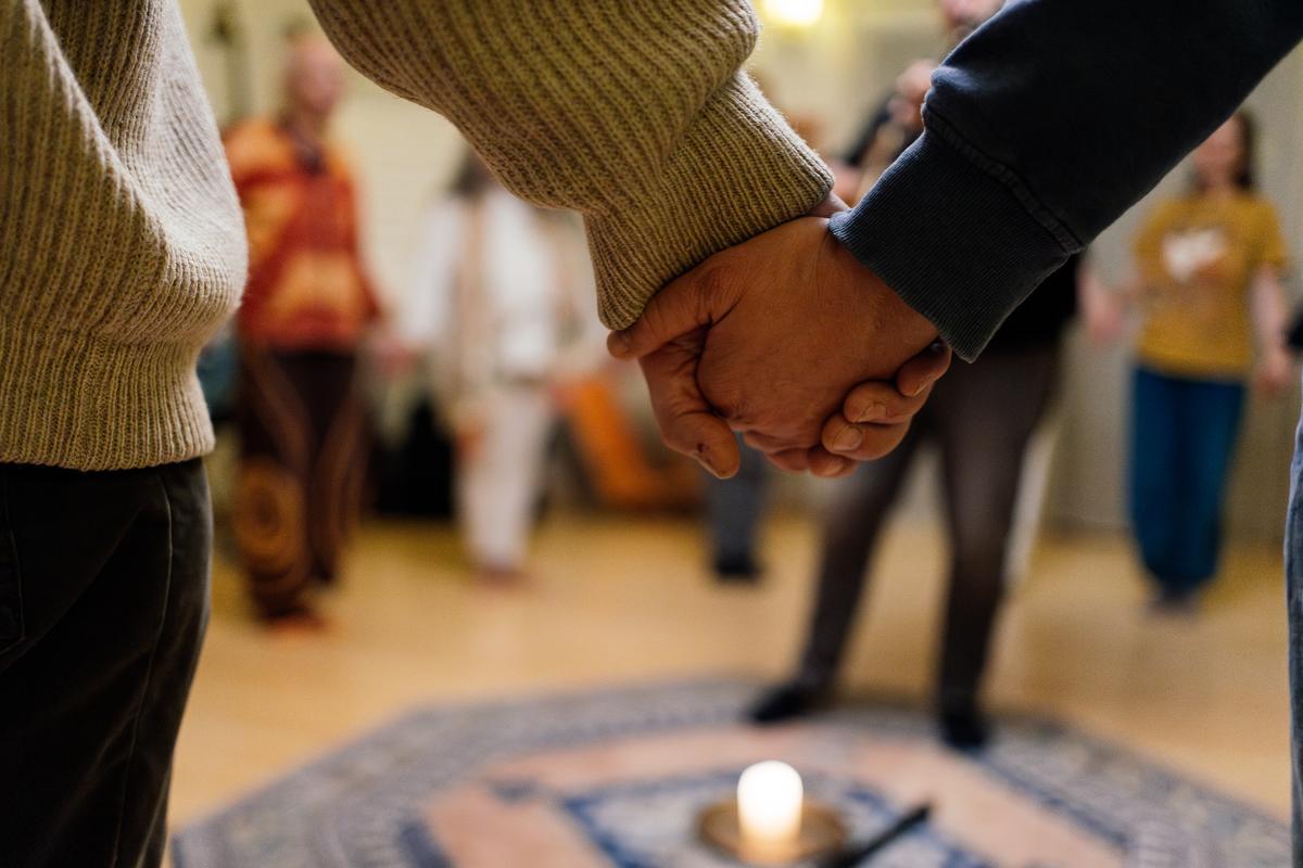 Menschen gehen Hand in Hand durch einen Seminarraum