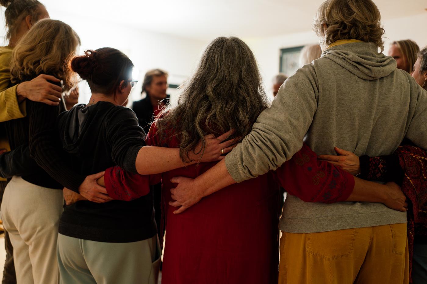 Menschen stehen Arm in Arm im Kreis